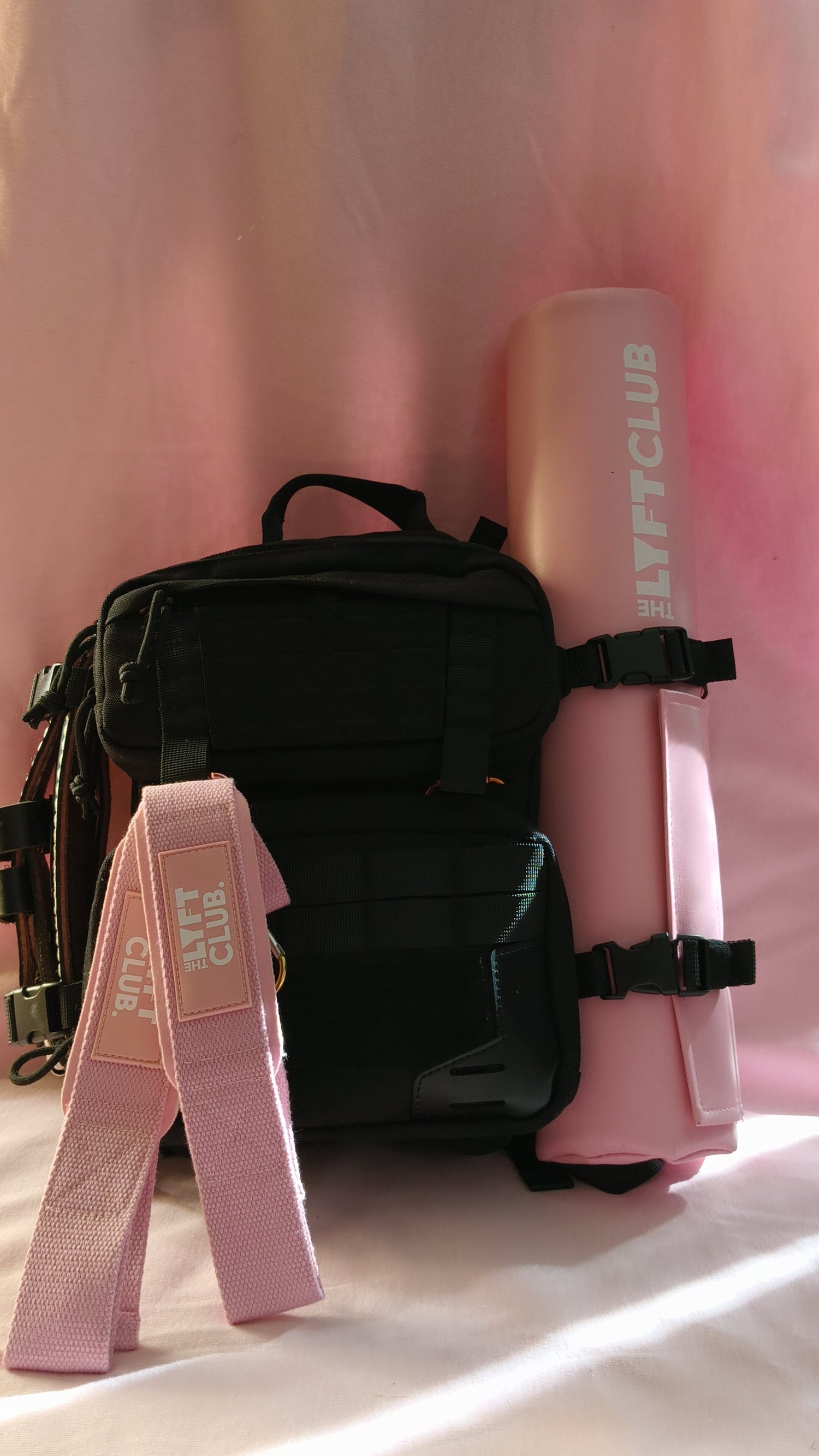 Black bag with pink straps and ' LYFT CLUB' branding against a pink curtain background